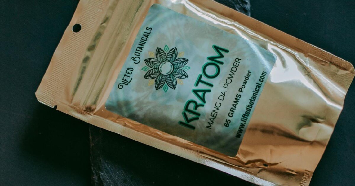 A sealed package labeled “Kratom Maeng Da Powder” is displayed on a dark surface, representing packaged kratom products.